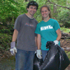 People picking up trash by stream